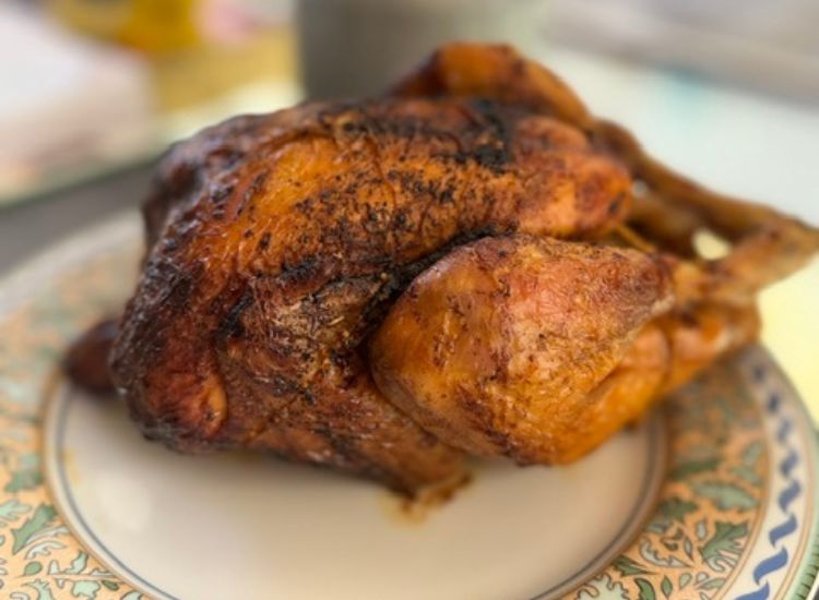 Poulet rôti doré et croustillant servi dans une assiette décorée, spécialité de la rôtisserie